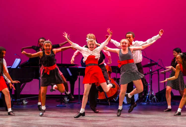 Young Tappers Jump for Joy in a Tap City Youth Concert. Students wear variations black whit and red..